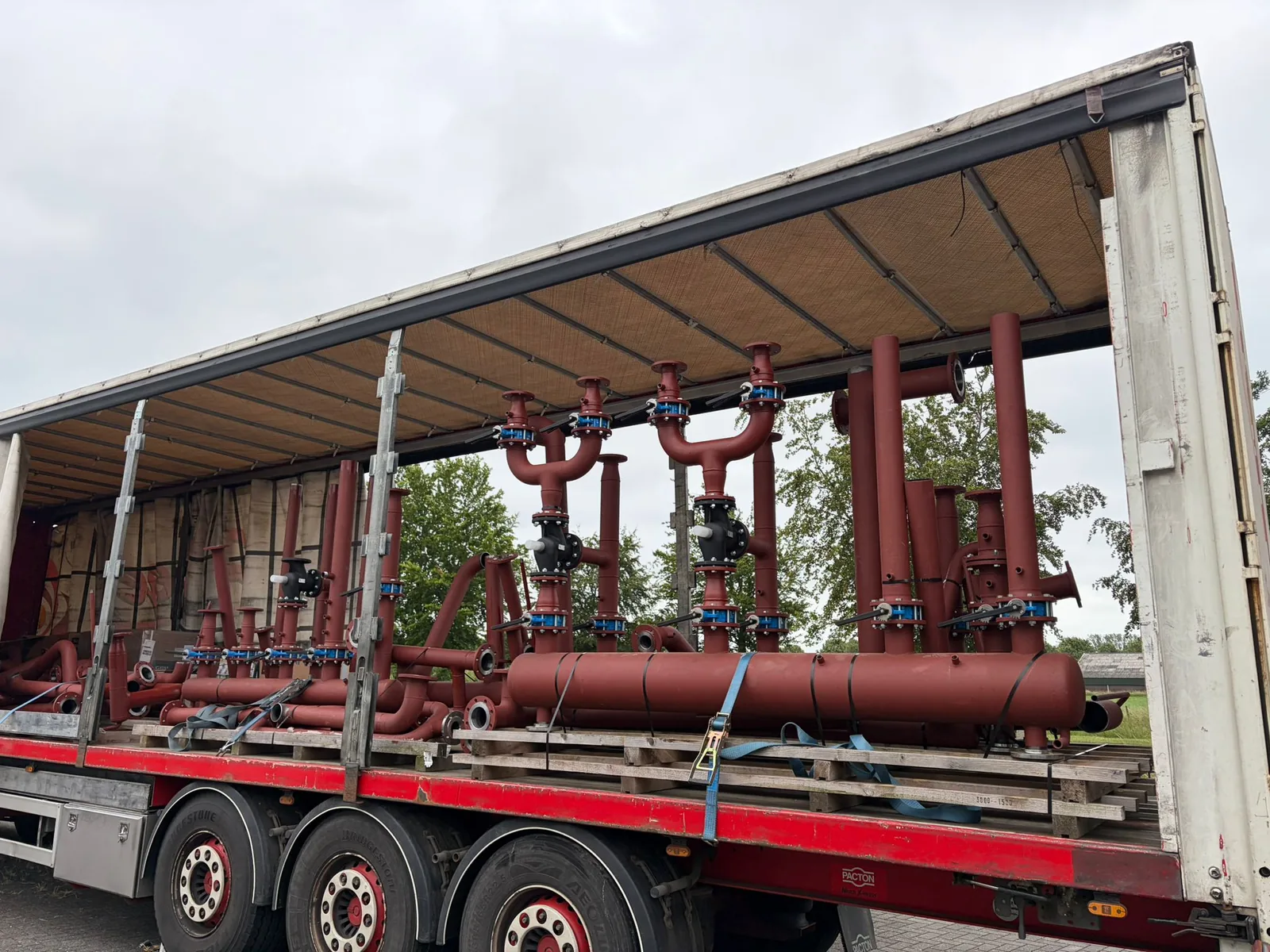 Gelaste stalen buizenconstructies gebundeld op een oplegger, klaar voor transport